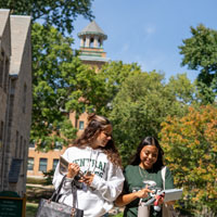 Two students walking towards the camera in front of T. Berry Smith